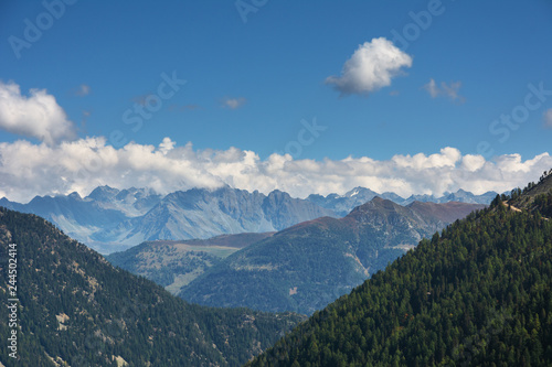 Landscapes of the Swiss alpine mountains against the background of a blue sky with small clouds.