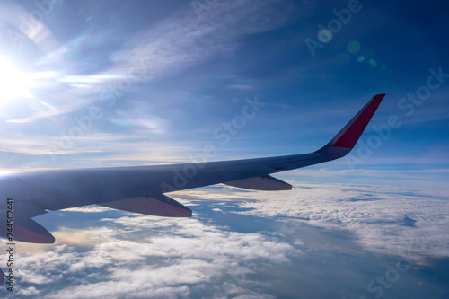 The wings of the plane flying over the white clouds in the daytime