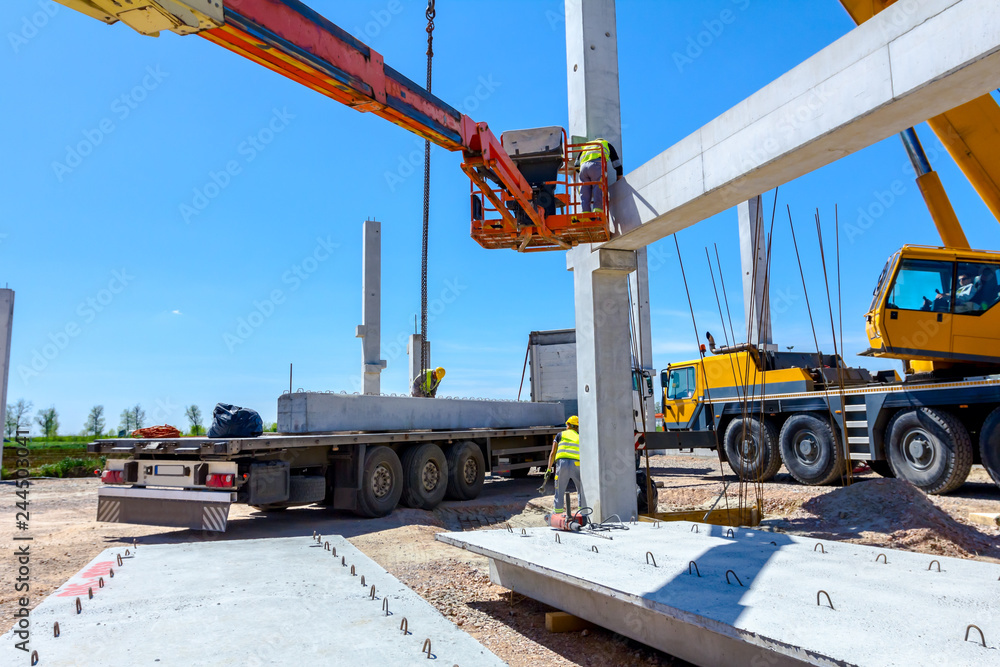 Worker is helping crane from cherry picker, keep balance and direction