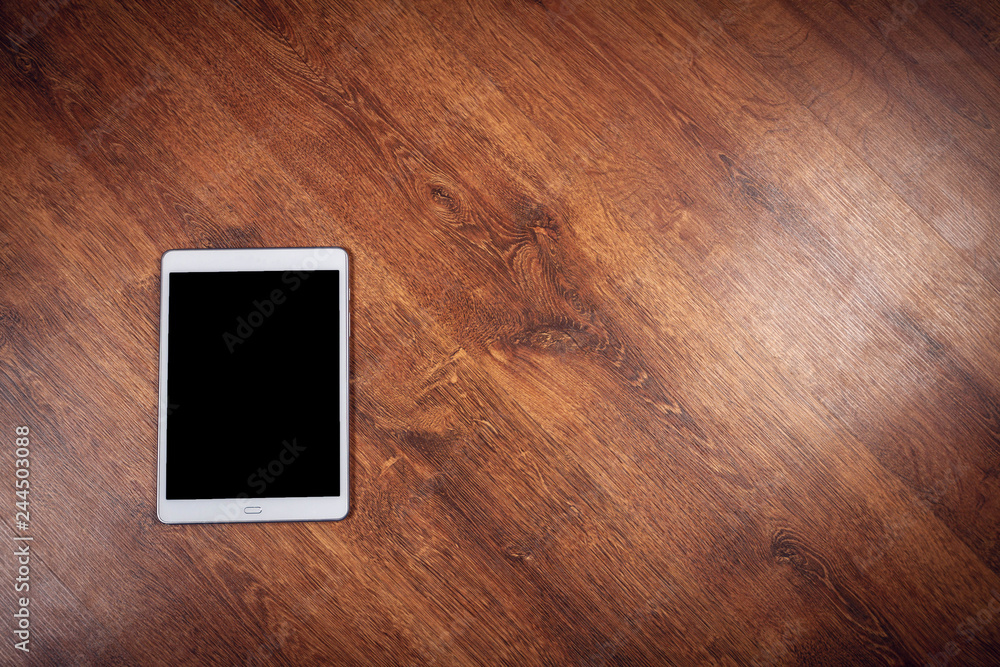 Old white tablet pc on wooden background Old white tablet pc on wooden background