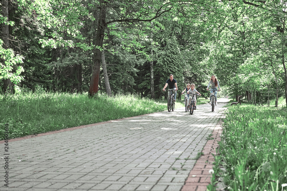 family with two children on a bike ride in the city Park family with two children on a bike ride in the city Park
