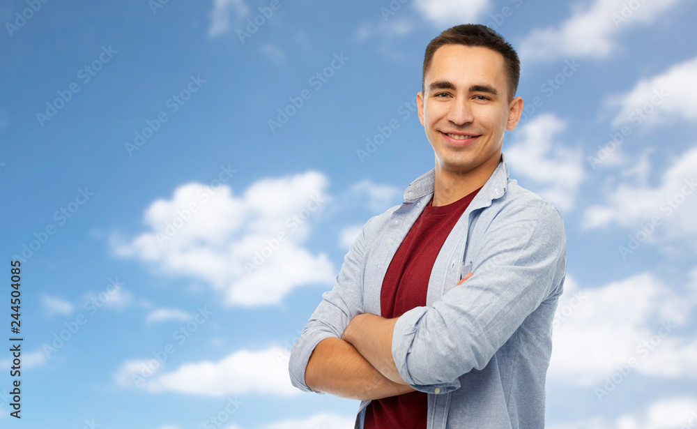 people concept - smiling young man over blue sky and clouds background people concept - smiling young man over blue sky and clouds background
