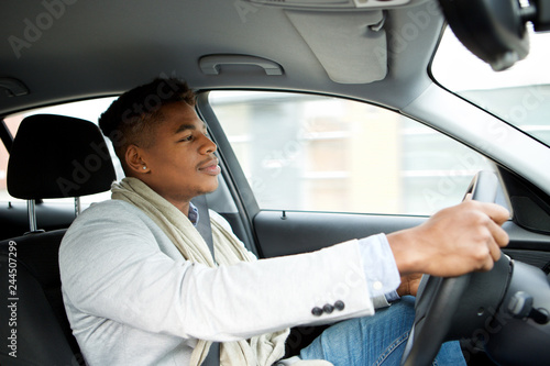 handsome young african american man driving car © mimagephotos