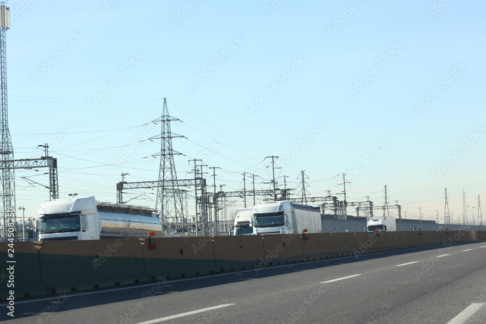 Fototapeta premium highway with trucks and eleitric trellis on the background