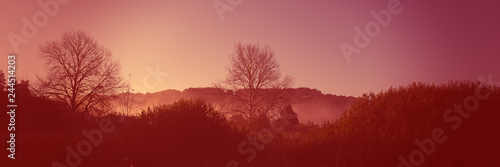 Dawn in the hilly terrain  meadow landscape countryside. Autumn season. Web banner for design. Color coral tonality.