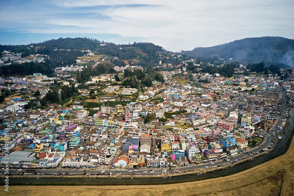Aerial view of colorful houses of Ooty city on Nilgiri mountains at Udhagamandalam, Tamil Nadu, India. Urban landscape.