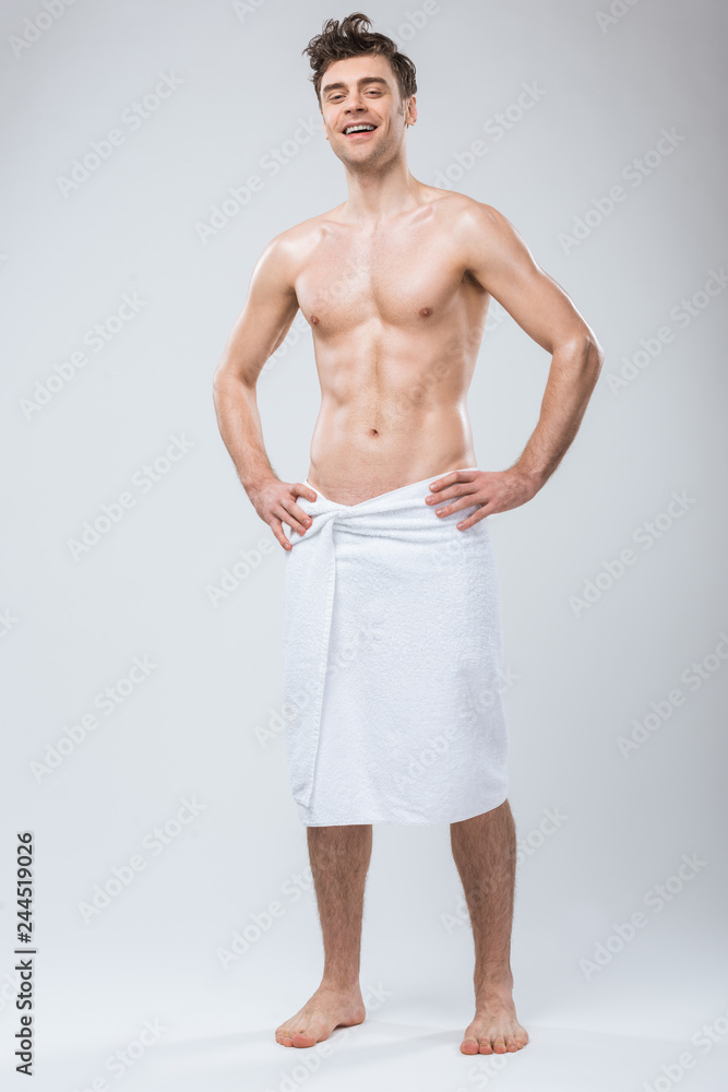 Fototapeta premium happy sexy shirtless man posing in towel isolated on grey