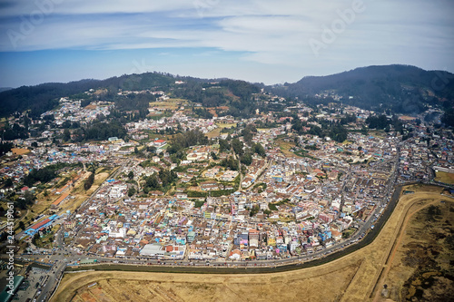 Aerial view of colorful houses of Ooty city on Nilgiri mountains at Udhagamandalam, Tamil Nadu, India. Urban landscape.