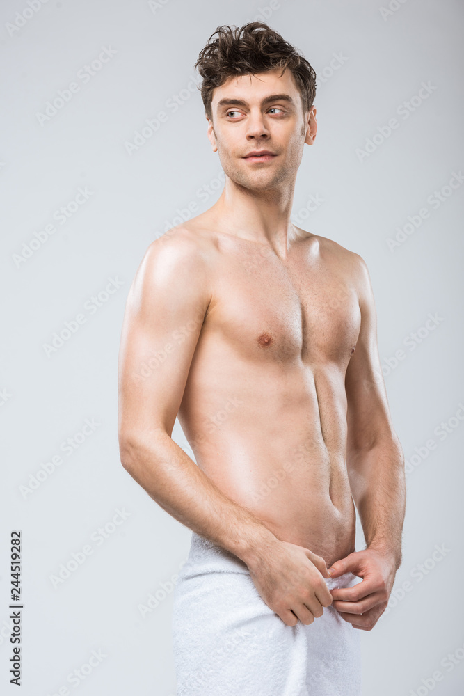 handsome shirtless man posing in towel isolated on grey