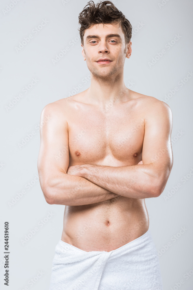 handsome shirtless man in towel posing with crossed arms isolated on grey