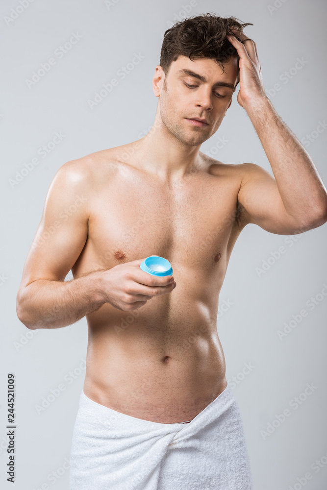 handsome shirtless man applying hair styling gel, isolated on grey