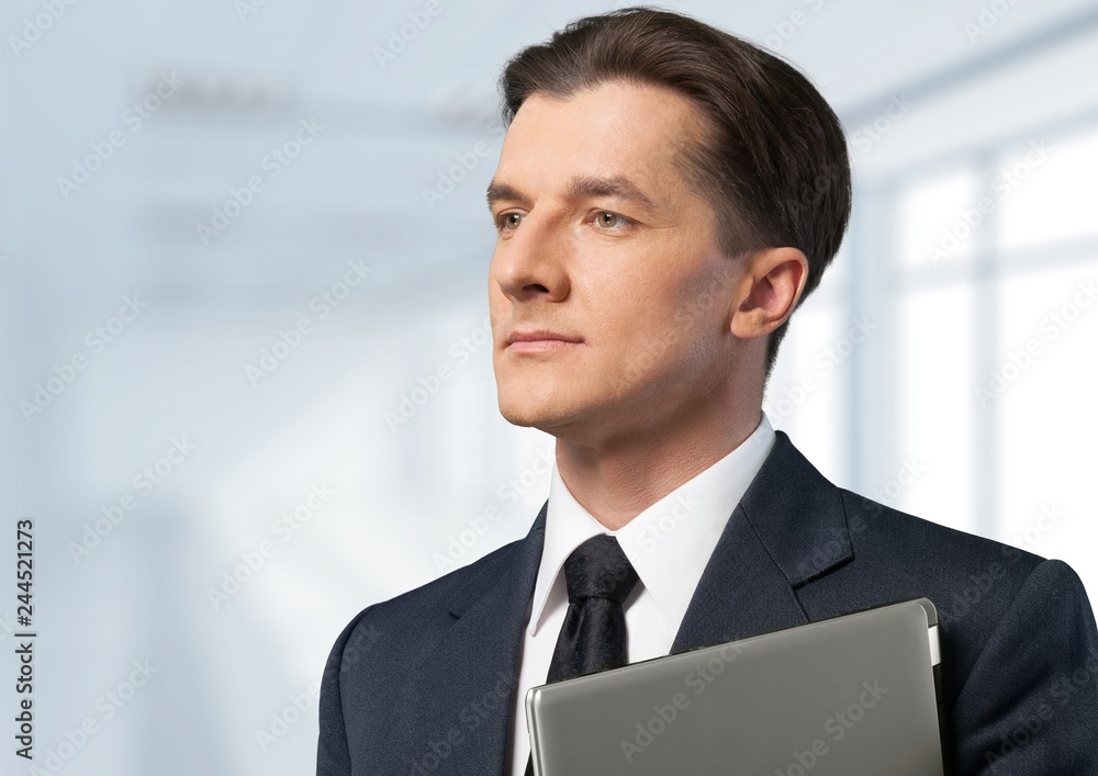 Male businessman with notebook on office background Male businessman with notebook on office background