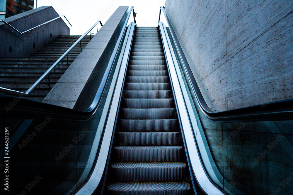Escalator raising to the sky, concept image of arrival to success Escalator raising to the sky, concept image of arrival to success