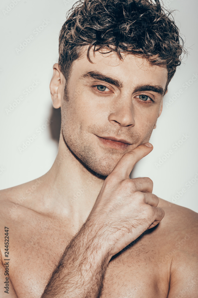 Fototapeta premium portrait of handsome young smiling man on grey