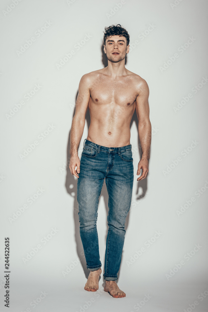 Fototapeta premium sexy shirtless macho in jeans posing on grey