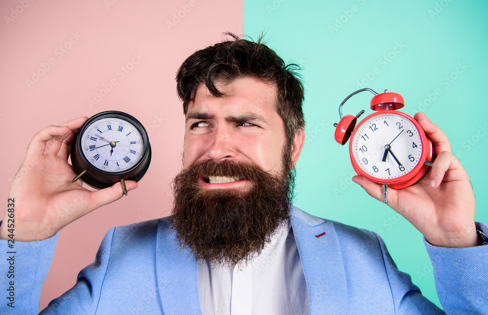 Man Changing Time Does changing clock mess with your health. Man bearded hipster hold two ...