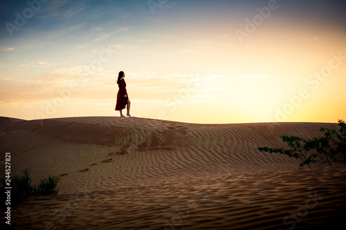 Woman watching sunset in a desert silhouette