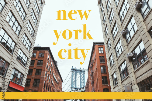 urban scene with buildings, brooklyn bridge and yellow "new york city" lettering in new york, usa