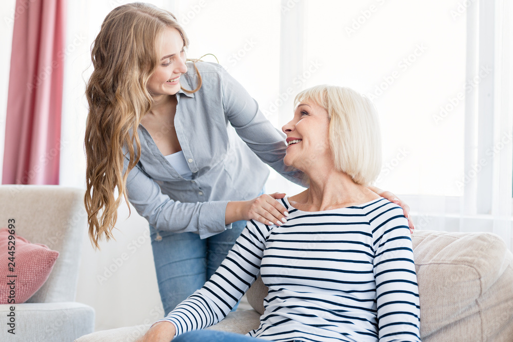 Positive woman and her daughter resting at home