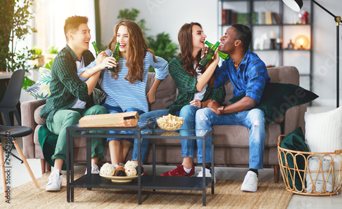 group of happy friends with beer and pizza at home