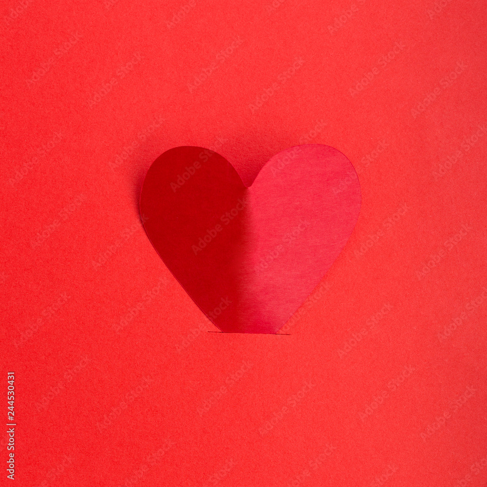 Paper heart on red paper background. Flat lay