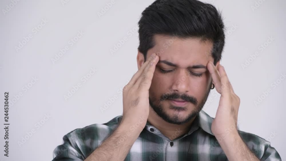 Young stressed bearded Indian man having headache Young stressed bearded Indian man having headache