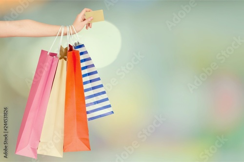 Woman with shopping bags and card on mall background