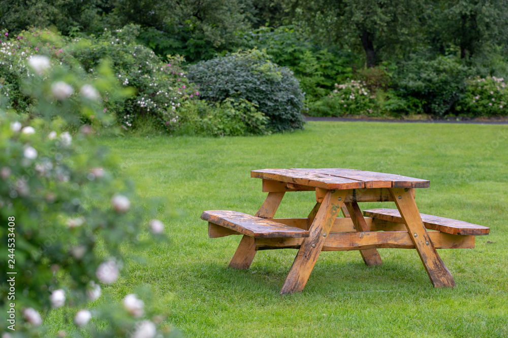 Picnic table with benches standing on grass