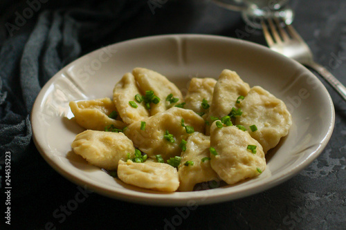 dumplings in a white plate (stuffing dough, different fillings). food background. dark background. top photo