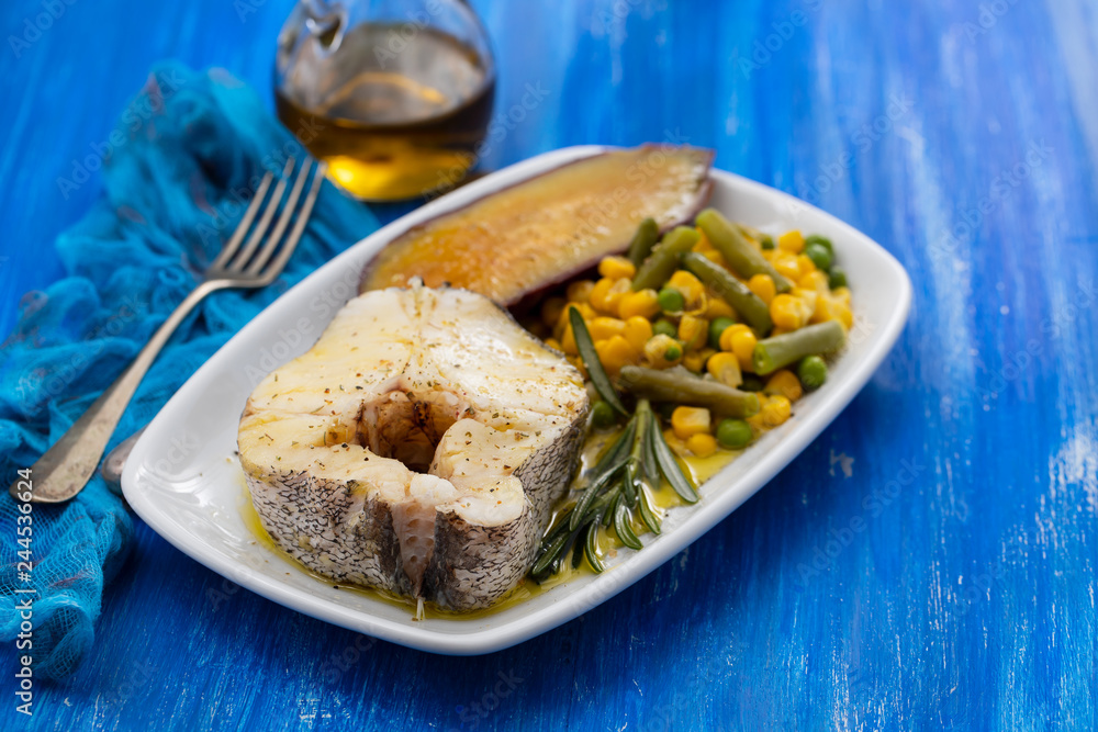 boiled fish with vegetables on white dish