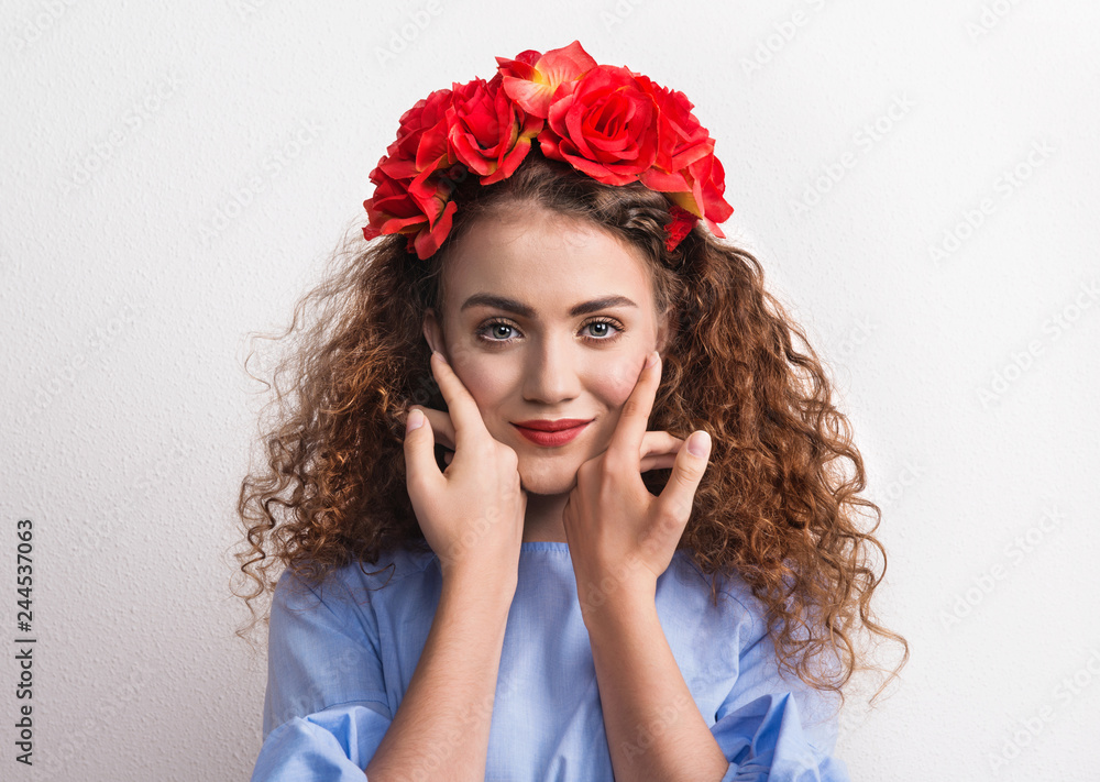 A front view of young beautiful woman with red flower headband.