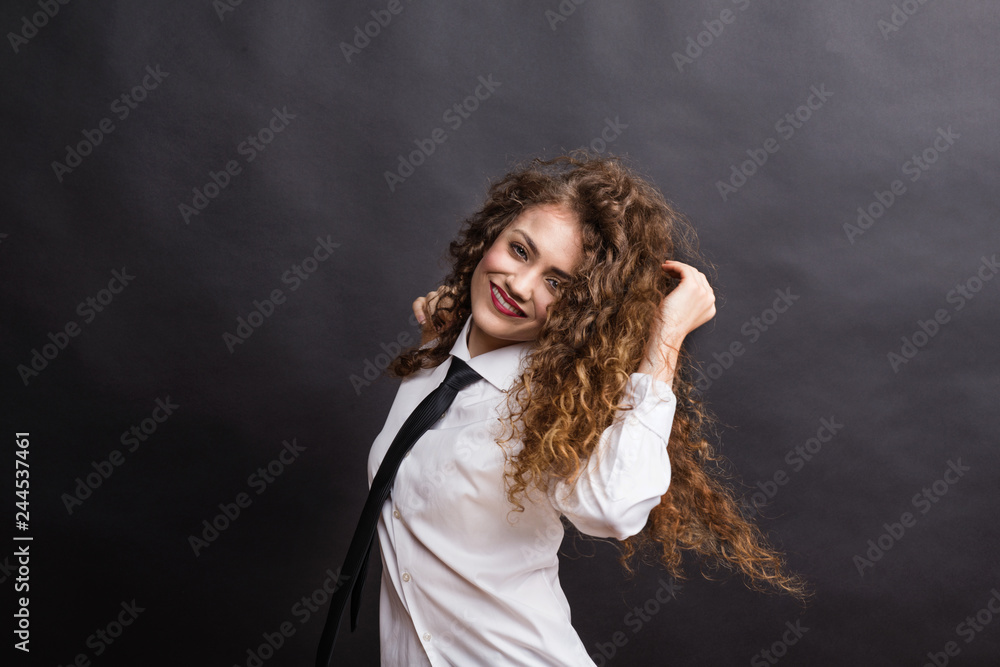 Young beautiful happy woman in studio, wearing white shirt and black tie. Young beautiful happy woman in studio, wearing white shirt and black tie.