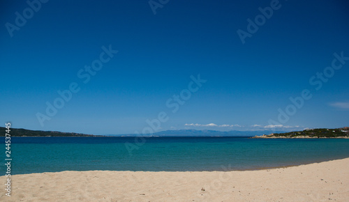 Splendida spiaggia tranquilla  con mare cristallino turchese e cielo blu a Porto Pollo  Sardegna. Sullo sfondo si vede la Corsica