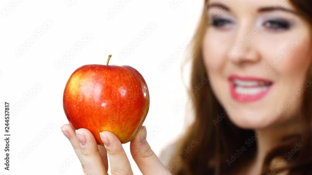 Young brunette woman recommend healthy eating diet, holding red apple in hand, focus on fruit, isolated on white Young brunette woman recommend healthy eating diet, holding red apple in hand, focus on fruit, isolated on white