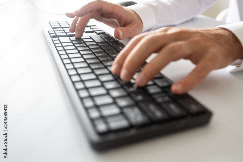 Closeup view of male hands using black computer keyboard Closeup view of male hands using black computer keyboard