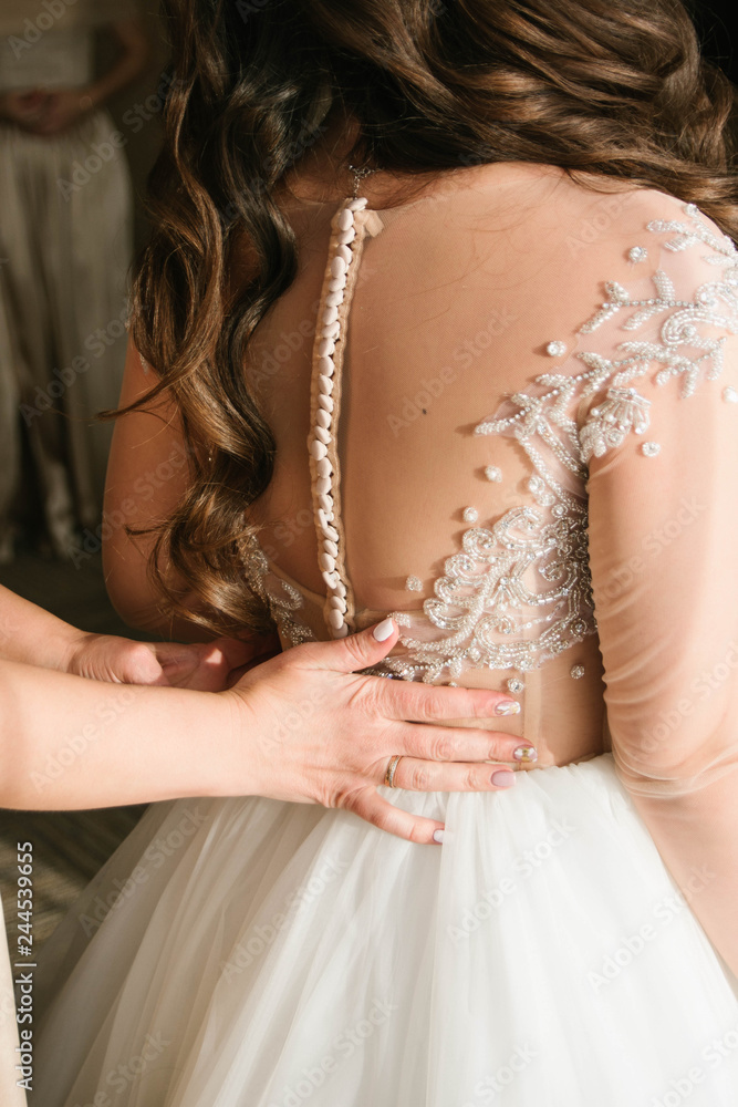 bride puts on a wedding dress
