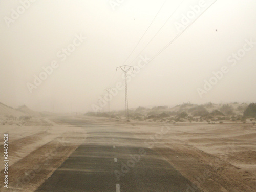 Road next to the Sahara desert during a sandstorm