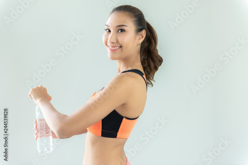 Healthy athletic asian woman is drinking pure water from the bottle refreshing herself after exercise. Healthy and Lifestyle Concept