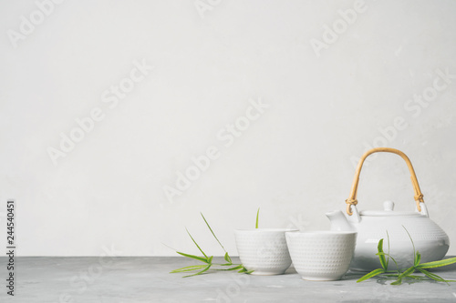 Asian food background set with green tea, cups and teapot with free space for text on white background.