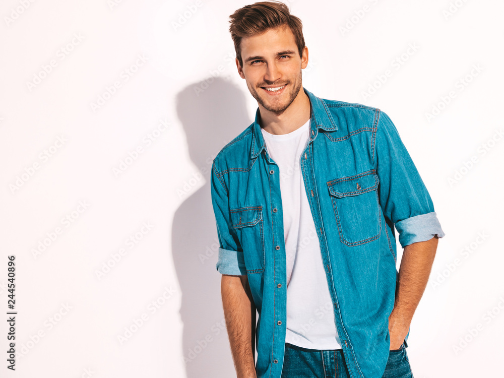 Portrait of handsome smiling stylish hipster lumbersexual businessman model dressed in jeans clothes. Fashion man. Isolated on white