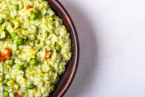 Traditional Italian vegetarian risotto with peas in rustic style, copy space for recipe