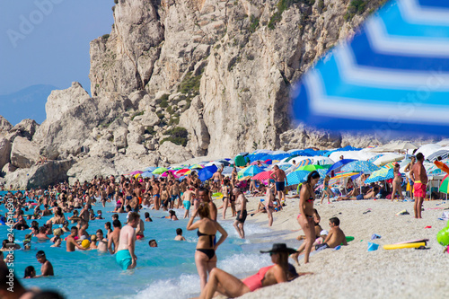 lefkada,greece,20/8/2018 overcrowded rocky beach in the heart of the summer photo