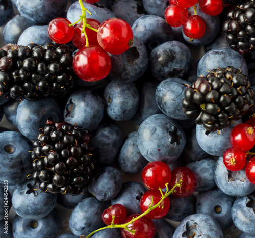 Texture berries close up. Top view. Black-blue and red berries. Ripe blueberries, blackberries and red currants. Various fresh summer berries.