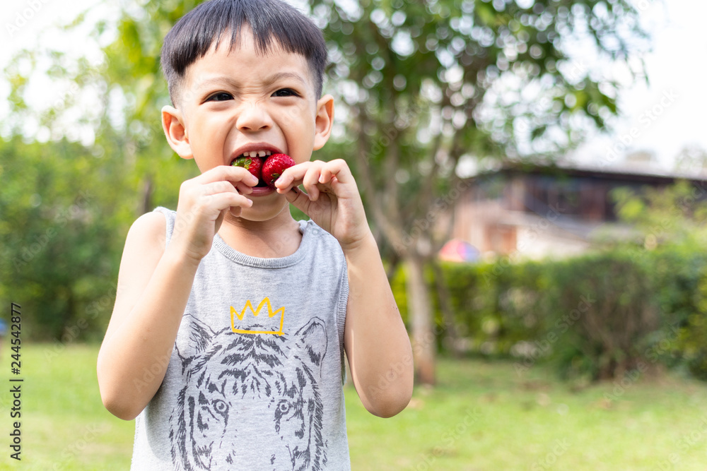 Children eating strawberries.