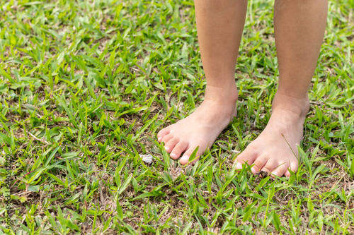 Baby's foot stepping on the grass. © lllonajalll