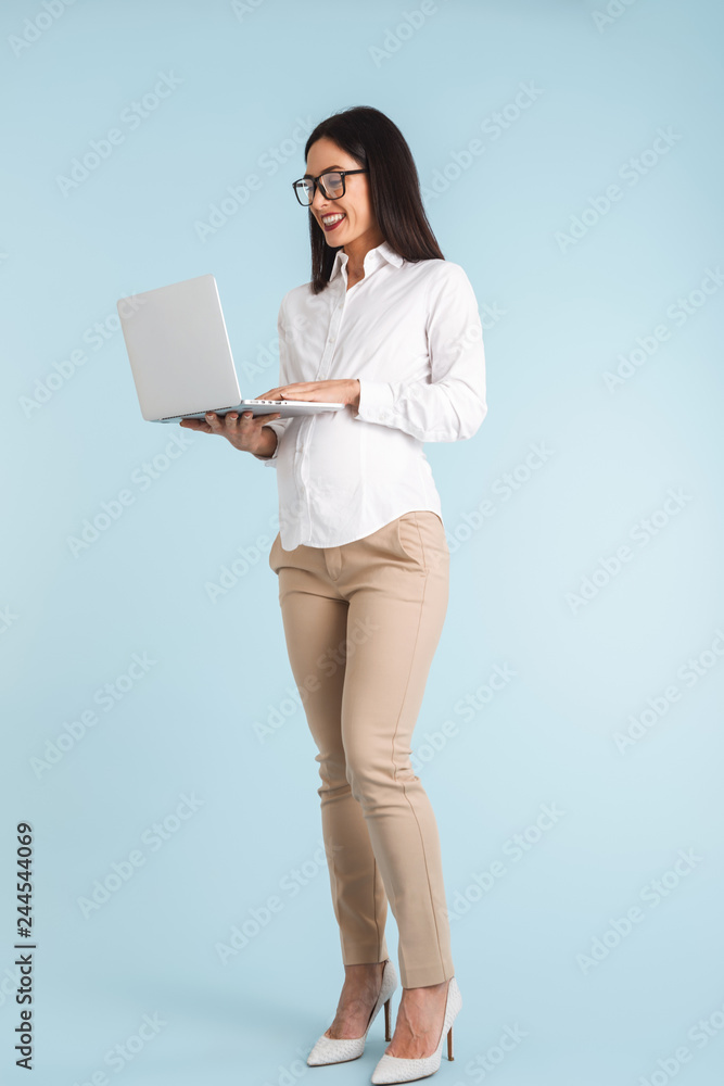 Business woman isolated over blue wall background using laptop computer. Business woman isolated over blue wall background using laptop computer.