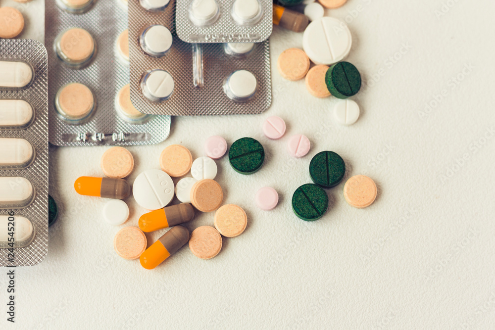 Medicine green, pink and yellow pills or capsules on white background with copy space. Drug prescription for treatment medication. Blister pack. Medicine green, pink and yellow pills or capsules on white background with copy space. Drug prescription for treatment medication. Blister pack.
