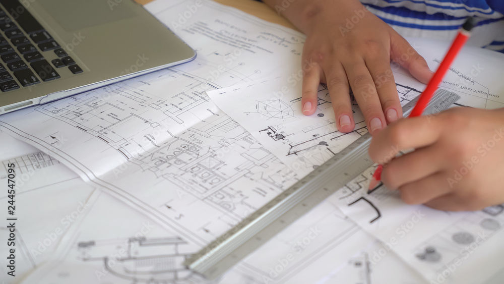 Woman holding pencil and ruler drawing some details. Woman holding pencil and ruler drawing some details.