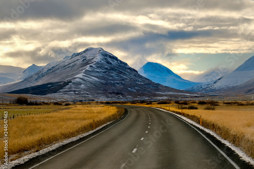 route in iceland with snow mounrtain background. afternoon time gold cloudy