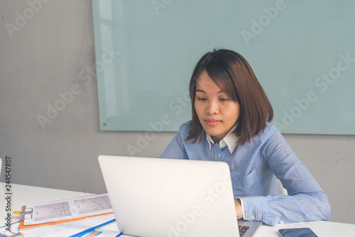 Young Asian businesswoman reading financial report in the office